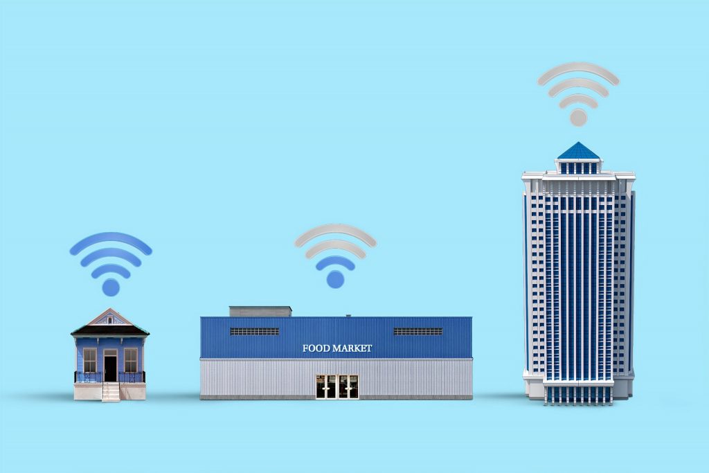Desenho de uma casa, um mercado e um prédio, ilustrando que a IoT (internet das coisas) pode atuar em todos os setores.