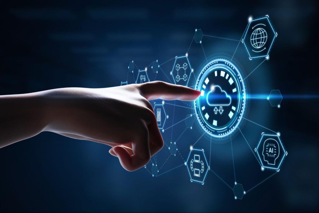  uma mão humana está tocando uma superfície com símbolos digitais projetados em cores de tons azul. No centro dele, está o símbolo de uma nuvem, representando a implantação de serviços em nuvem.