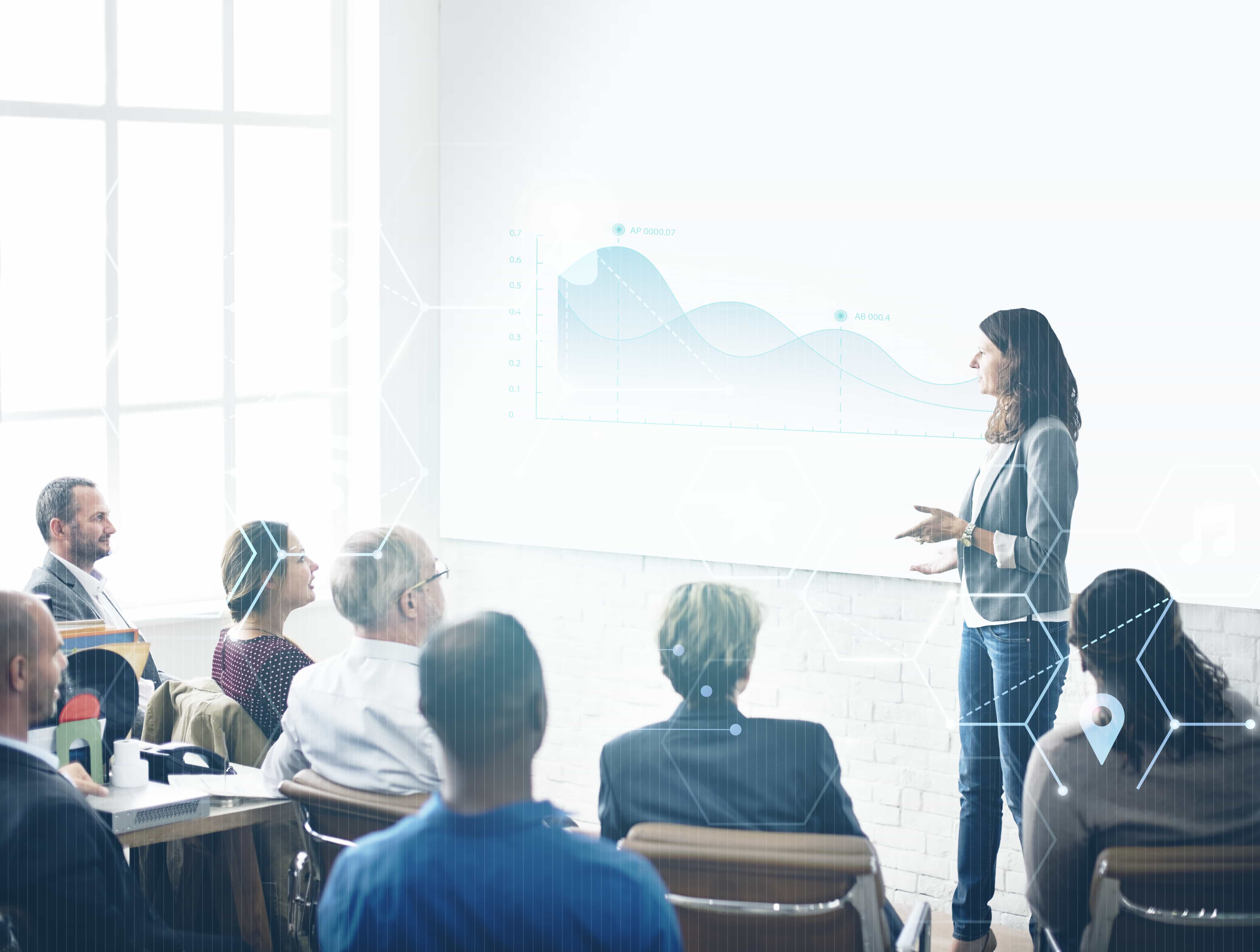 Imagem mostra uma mulher apresentando dados em uma palestra.
