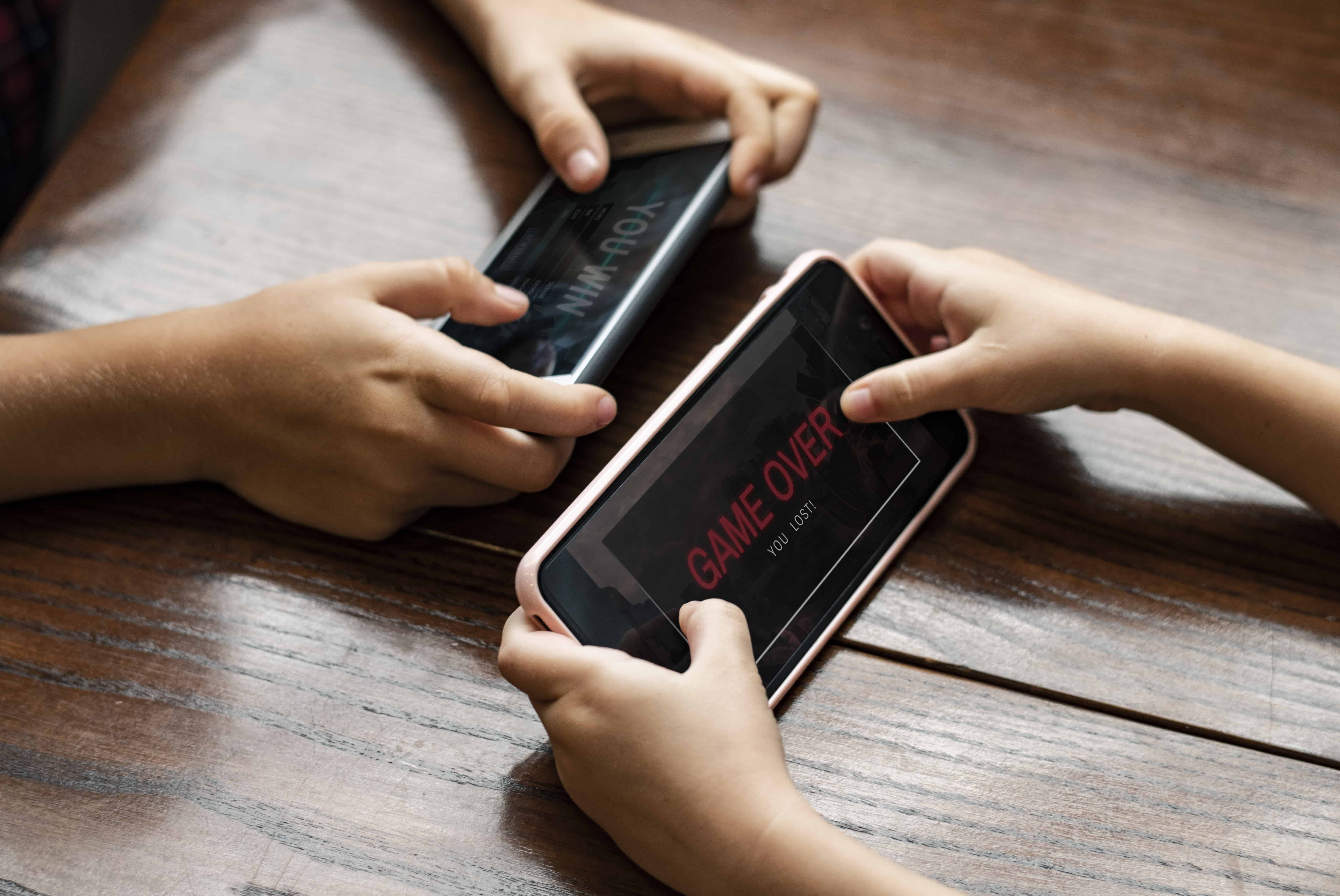 Duas pessoas jogando em celulares