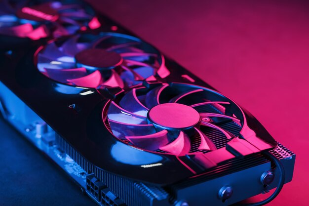 Close-up de uma placa de vídeo com três ventoinhas, iluminada em tons de rosa e azul.