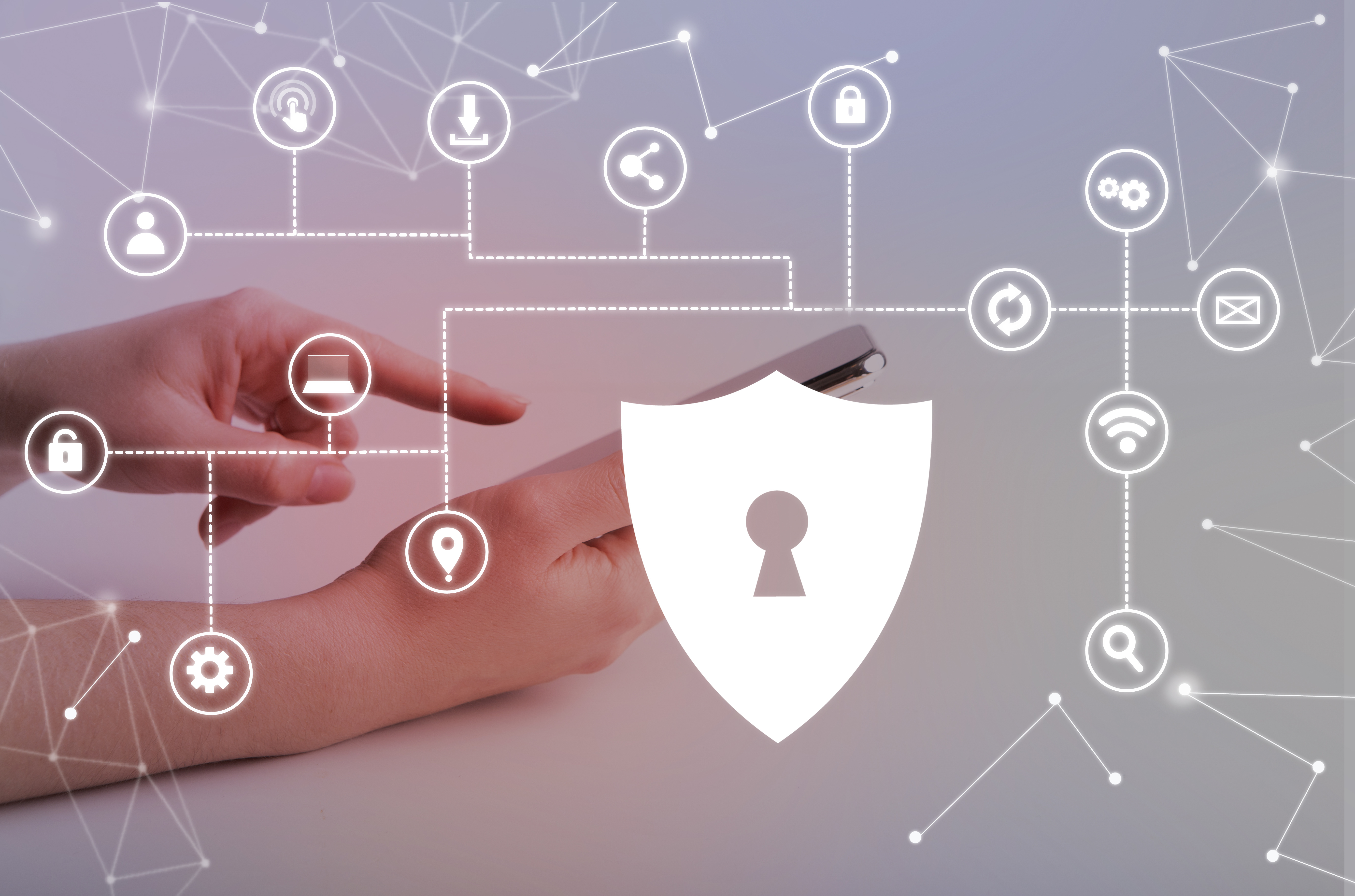 endpoint security imagem com fundo em tons de cinza e algumas linhas pontilhadas conectando diferentes ícones, alguns deles representa um computador, uma engrenagem, uma localização, uma cadeado, um wifi, uma lupa, entre outros. No canto esquerdo, há duas mãos, uma segurando um celular e outra apontando para a tela do mesmo, no canto direito há um símbolo branco que lembra um escudo com uma fechadura desenhada ao centro. Toda a imagem faz alusão ao endpoint security