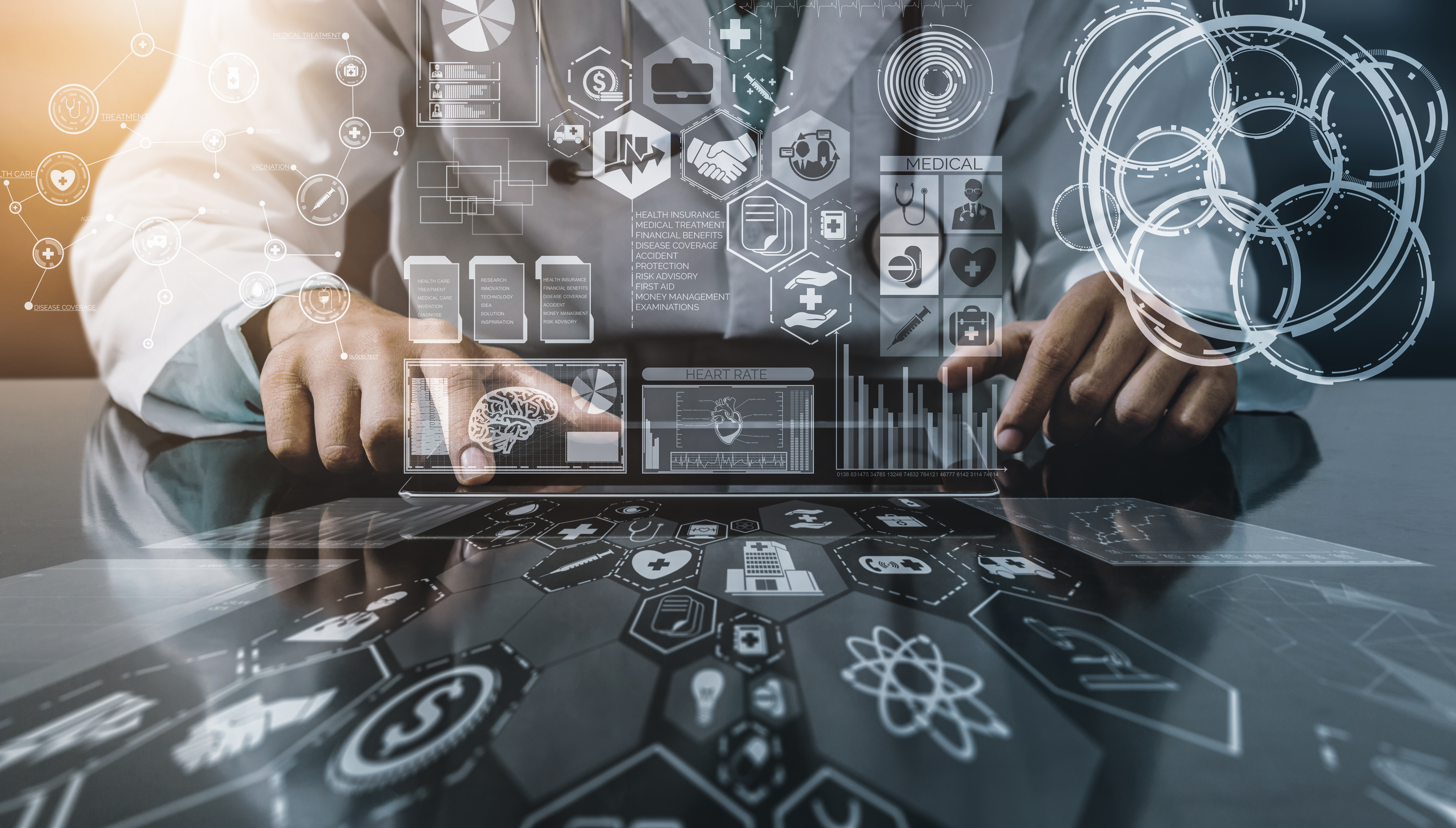 Imagem com desenhos de círculos e símbolos de informática ao redor, no centro há uma pessoa usando um jaleco e teclando na mesa que projeta os desenhos, a fotografia está representando a inovação na saúde