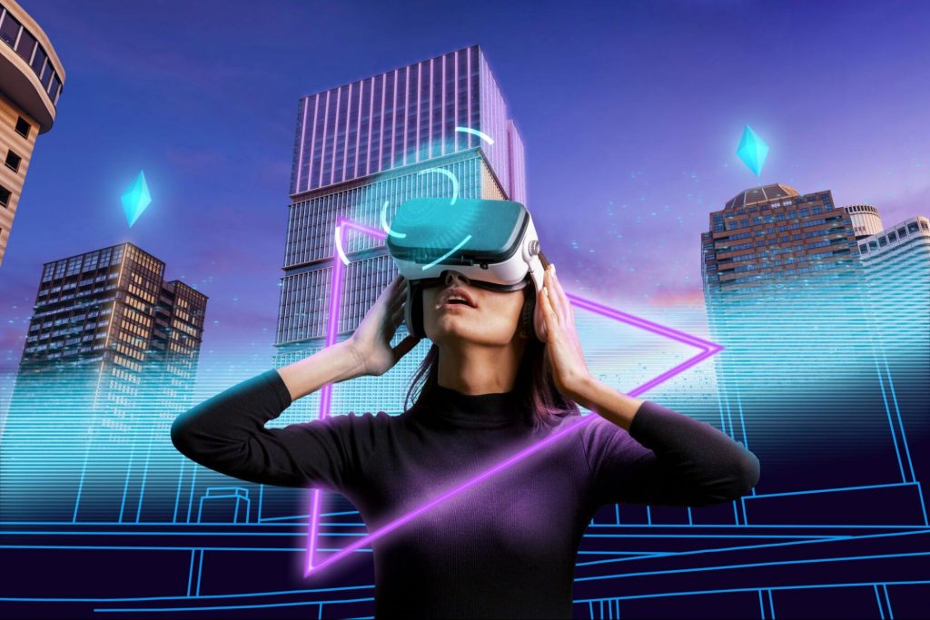 Imagem de uma fotografia com o fundo de uma cidade com prédios, na frente há uma mulher utilizando óculos de realidade virtual, a imagem representa o uso de ferramentas envolvendo tecnologia e mercado de trabalho.