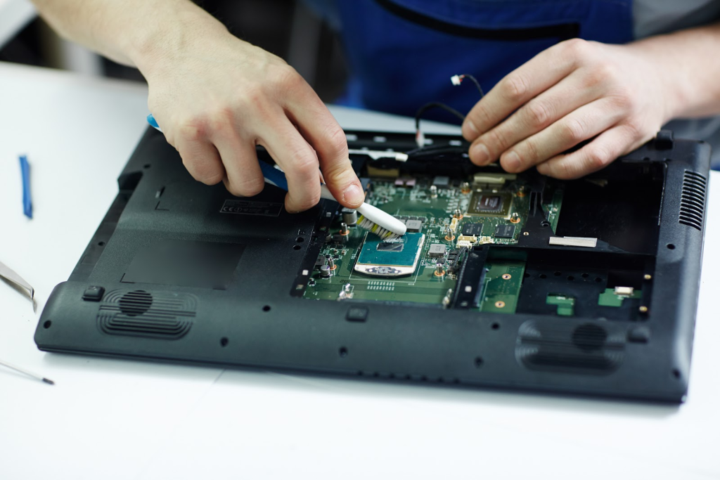 duas mãos de pele branca estão segurando equipamentos de montagem eletrônica para analisar o ssd de um notebook