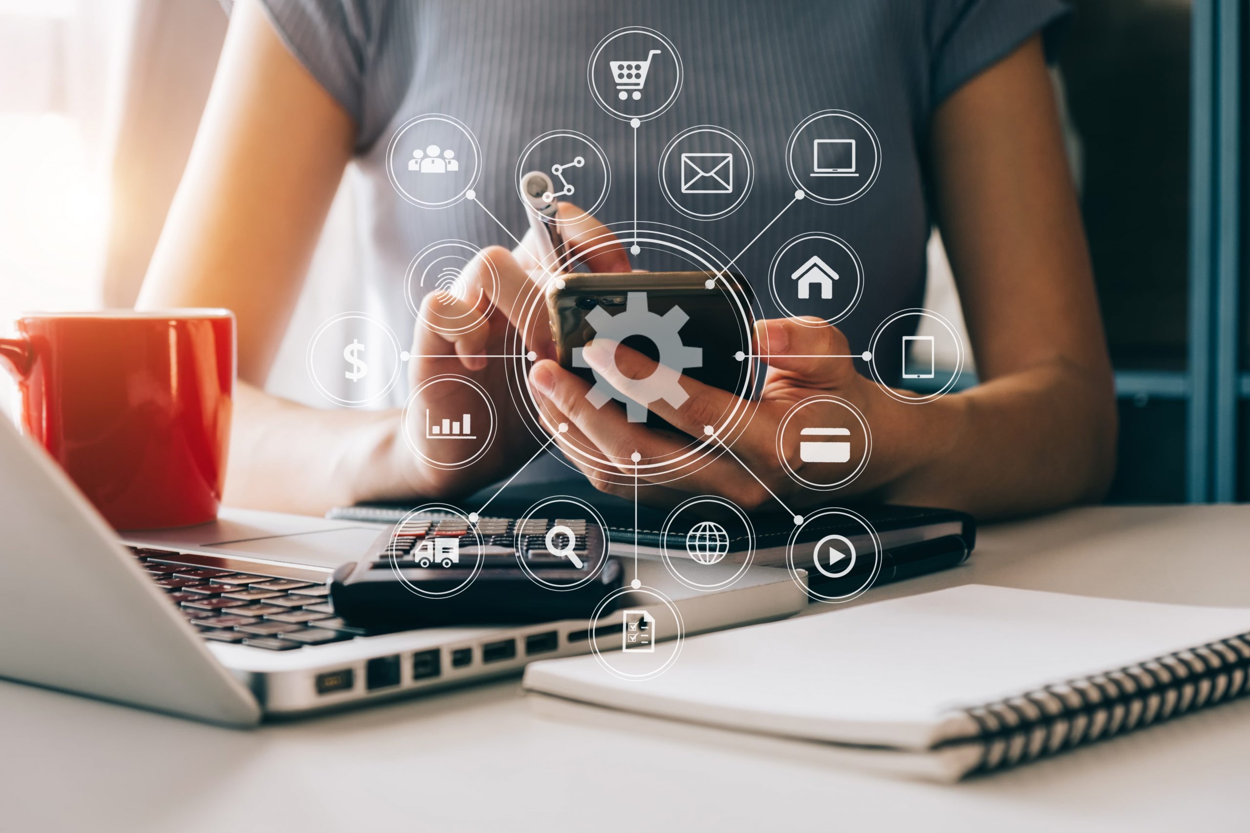 Mulher com celular em mãos projetando um holograma de ícones digitais