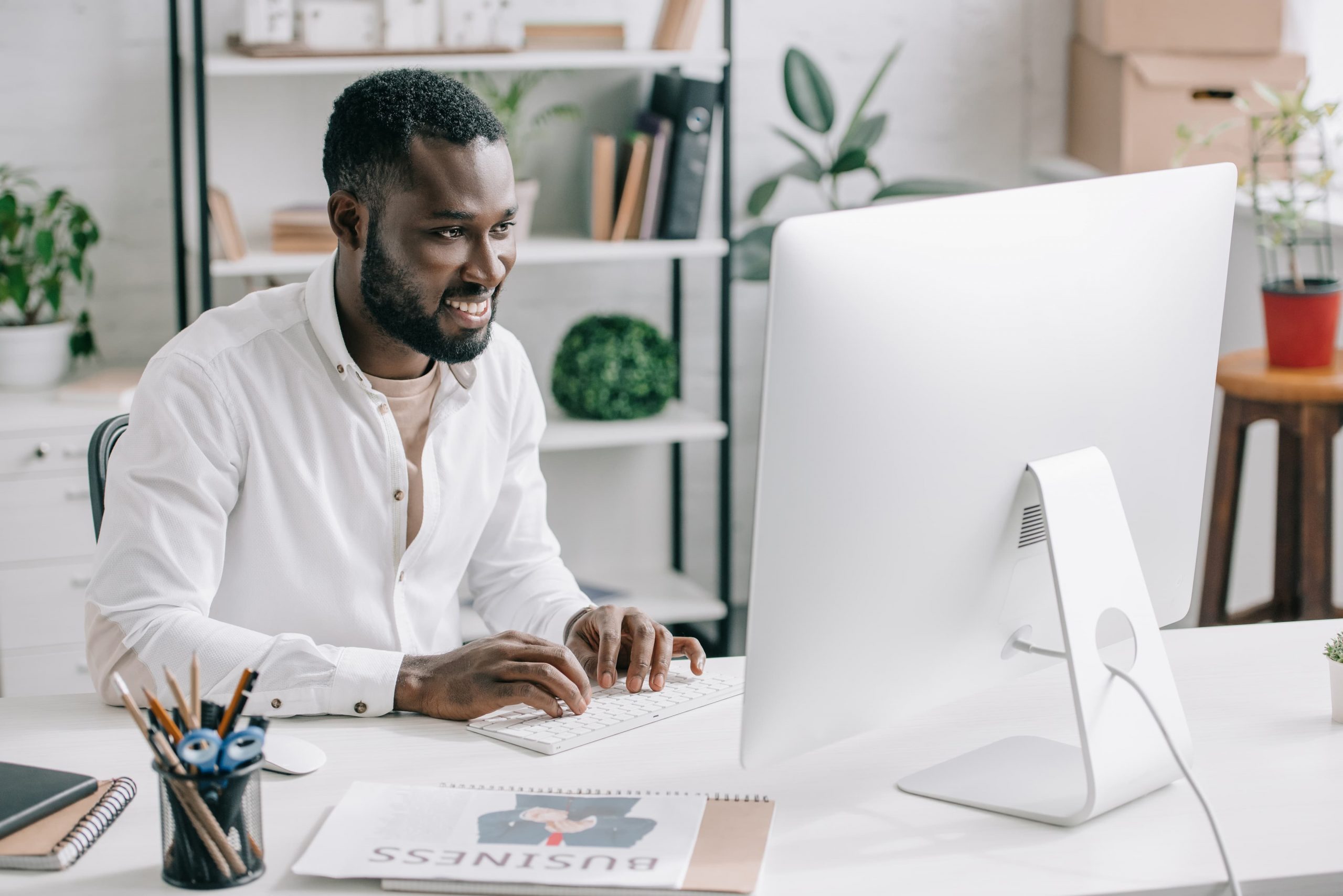 curso de cloud capa homem negro sentado em uma mesa de escritório e olhando para a tela de um computador