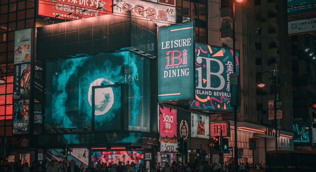 Diferentes telas de digital signage projetam propagandas em alfabeto ocidental e oriental. 