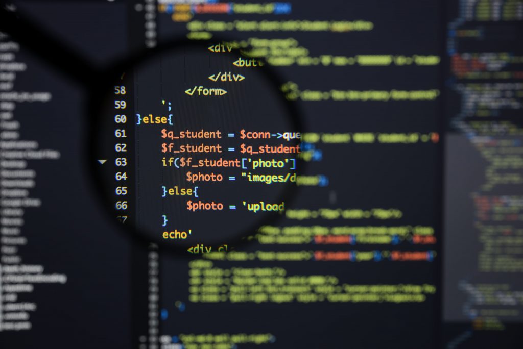Tela de computador em zoom com um código fonte em diferentes cores.