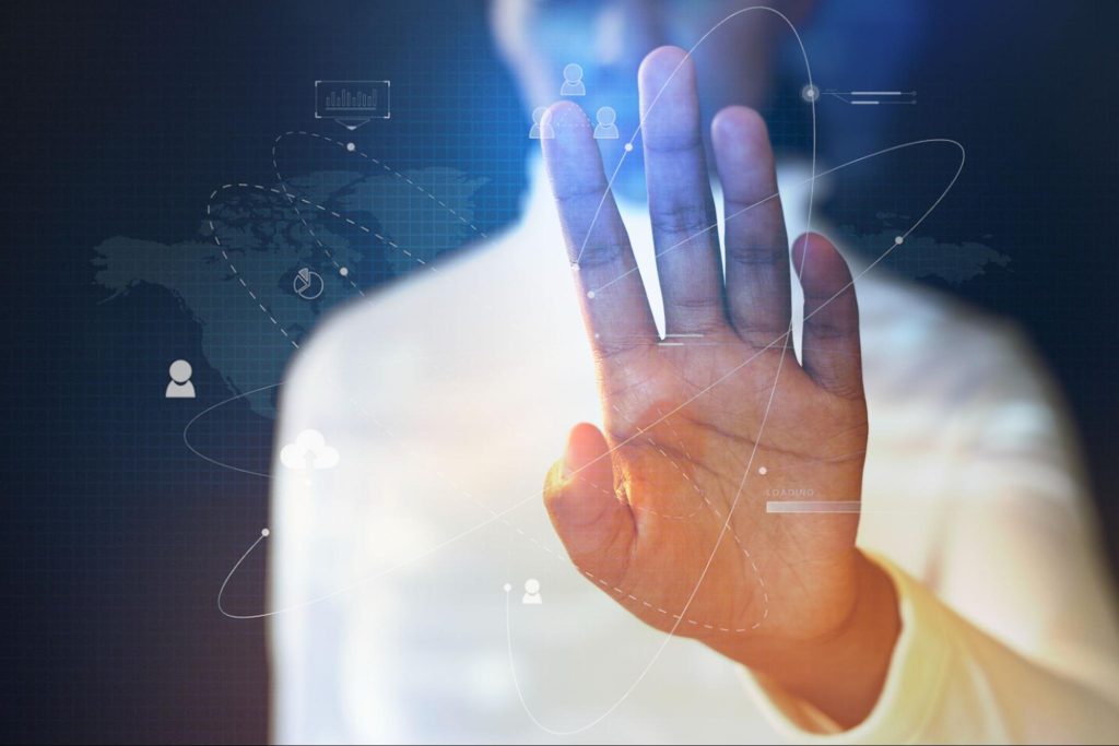 Homem negro, com mão a frente tocando a imagem de linhas conectadas, simbolizando a sincronização de tecnologias.