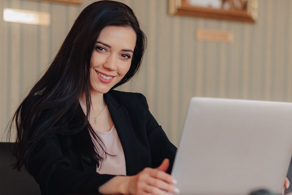 Profissional da tecnologia utilizando notebook em seu escritório, usando terno preto