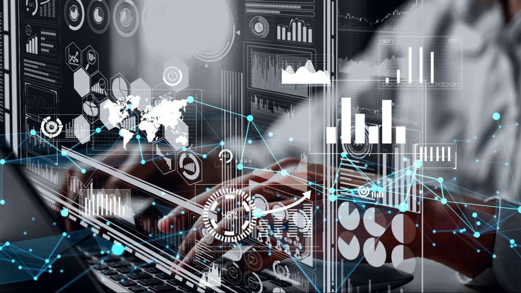 Homem trabalhando em frente a um computador, usando óculos. Ele parece concentrado, olhando para a tela em um ambiente iluminado por luzes azuis.