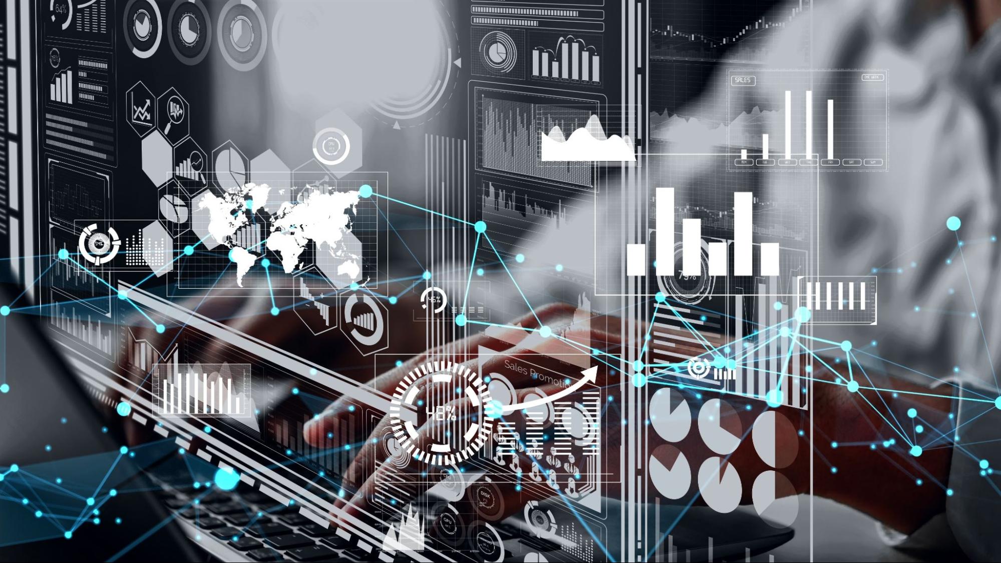 Homem trabalhando em frente a um computador, usando óculos. Ele parece concentrado, olhando para a tela em um ambiente iluminado por luzes azuis.